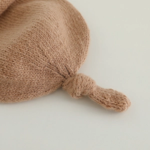 Bonnet en tricot marron pour bébé avec nœud supérieur et bordure roulée pour l'automne