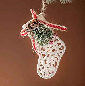 Detail of white hollow Christmas stocking with pine cones and red berries on brown backdrop
