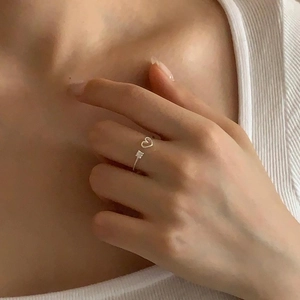 Close-up of adjustable silver heart ring with small zircon stone on model finger