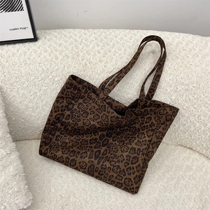 Detail shot of vintage suede leopard print tote bag on white textured sofa backdrop