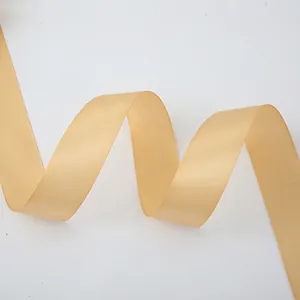Detail of champagne gold satin ribbon with glossy texture and smooth wavy curves