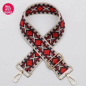 Detail of red and black geometric diamond pattern woven bag strap with gold metal buckles
