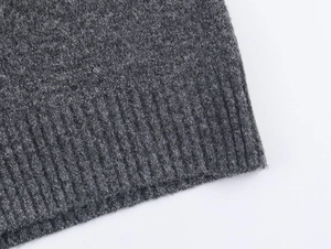 Detail of dark grey knit cardigan with shimmering silver metallic fibers and ribbed hem