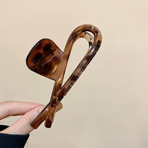 Detailed view of leopard print acetate hair claw clip with brown tortoiseshell texture