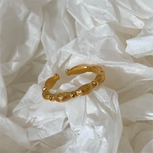 Detail of gold olive bead ring with S925 hallmark on minimalist textured metal band