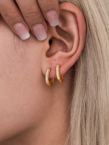 Close-up of 14mm gold hoop earrings with white zircon stones on a female model