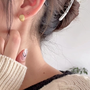 Minimalist matte gold 925 sterling silver ear studs with brushed finish on female model