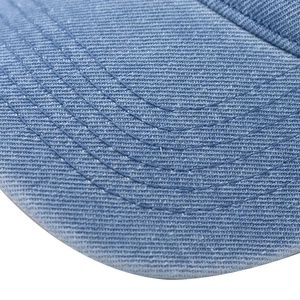 Detailed close-up of light blue washed denim brim with parallel stitching on a baseball cap