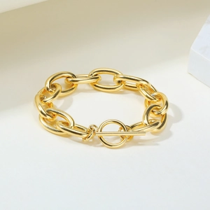 Macro shot of gold stainless steel chunky chain bracelet featuring a stylish OT toggle clasp