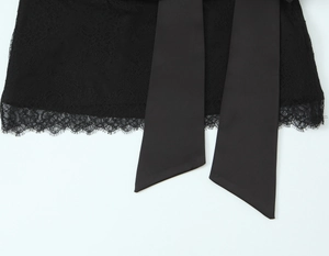 Detailed macro view of black floral lace fabric and wide satin ribbon tie straps
