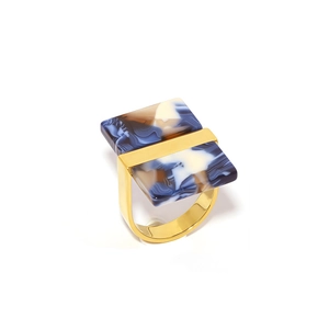 Detailed macro view of 18k gold U-shaped ring with blue marble texture resin inlay