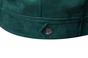 Macro shot of forest green faux suede jacket fabric with a metal classic button