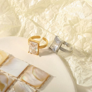 Close-up of gold and silver steel rings with rectangular cut crystals and beaded edges