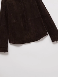 Detail of dark brown suede jacket featuring precise stitching and metal zipper cuff