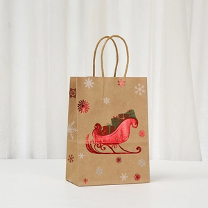 Detail of kraft paper Christmas gift bag featuring red foil sled and snowflake patterns