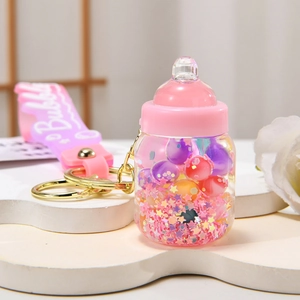 Cute milk bottle keychain with pink cap, colorful beads and starry glitter liquid charm