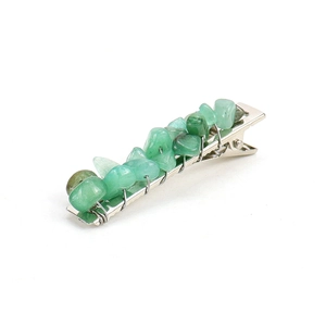Close-up of handmade green crystal chips wrapped on a silver metal alligator hair clip