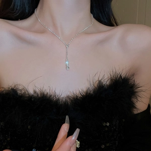 Gros plan d'un collier à pompon en strass étincelant avec pendentif en Y sur un mannequin