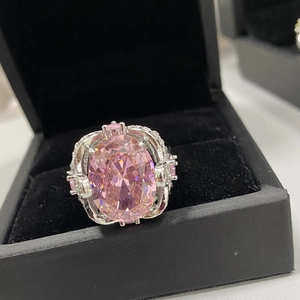 Macro detail of large pink oval gemstone ring in 18k silver setting inside black velvet box