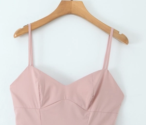 Détail de la robe rose à fines bretelles montrant le décolleté en V et les coutures