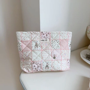 Detail showing quilted cotton floral makeup bag with cute cartoon rabbit and label
