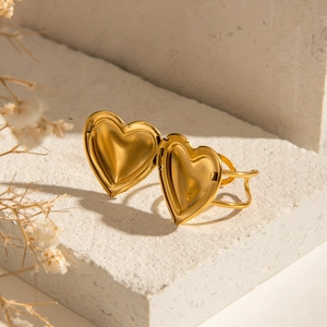 Détail d'une bague médaillon en forme de cœur doré ouverte avec compartiments photos