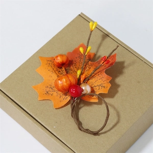 Detail of harvest napkin ring with maple leaf, mini pumpkins and berries on a vine base