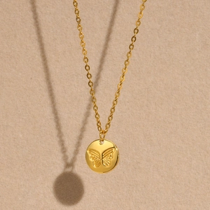 Minimalist gold stainless steel necklace featuring a round butterfly relief pendant