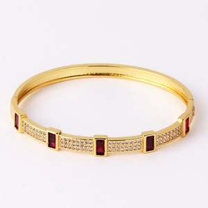Detailed close-up of gold-plated bracelet with red rectangle zircon and micro-pave crystals