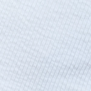 Détail macro de la texture du tissu en maille côtelée blanche du cardigan bohème