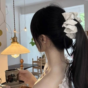 Elegant white oversized bow hair clip shown on model for a chic and aesthetic hairstyle