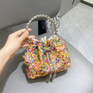 Detail of colorful beaded bucket bag with silver ring handle and metal chain tassels