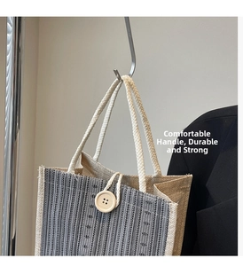 Detailed view of linen tote bag featuring vertical stripes and large wooden button
