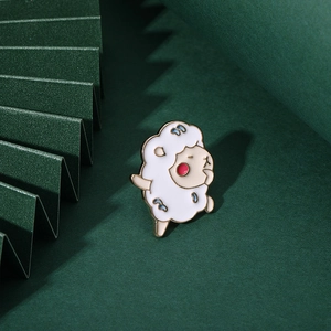 Cute cartoon lamb enamel brooch with gold-plated edges on a green textured background