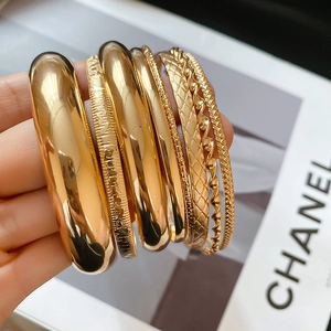 Vue macro détaillée d'un ensemble de huit bracelets joncs dorés texturés pour femmes