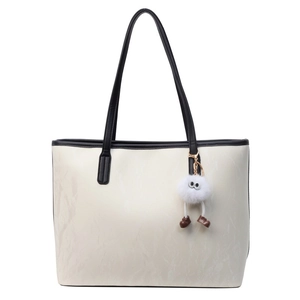Grande borsa tote minimalista beige e nera con un simpatico ciondolo in peluche morbido