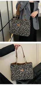 Detail of leopard print tote bag with leather straps and metal chain accents