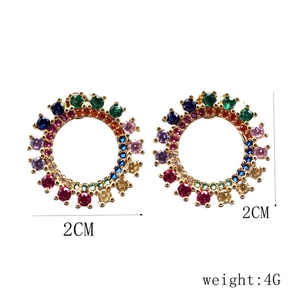 Dettaglio di orecchini a cerchio dorati con cristalli colorati, misura 2cm e peso 4g