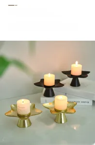 Star shaped metal candle holders in matte black and gold finish on tabletop