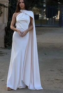 Detail eines weißen Satin-Abendkleids mit elegantem One-Shoulder-Cape und langer Schleppe