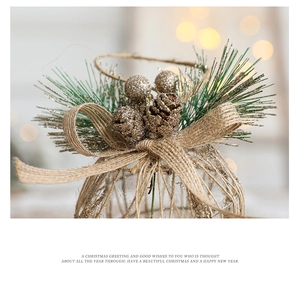 Detail of Christmas tree ornament with pine needles, glitter pinecone and burlap bow