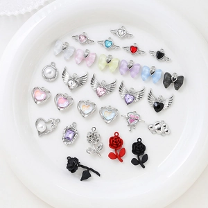 Assorted bow and heart alloy pendants with zircon and enamel on a white ceramic plate