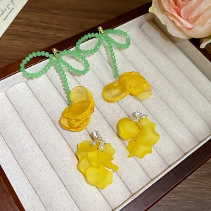 Orecchini a fiori con perline verdi e petali in tessuto giallo in una scatola di velluto
