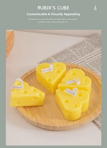Detail view of yellow cheese and heart shaped scented candles on a wooden tray