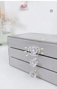 Detail view of multi-layer jewelry box with transparent lid and crystal handles