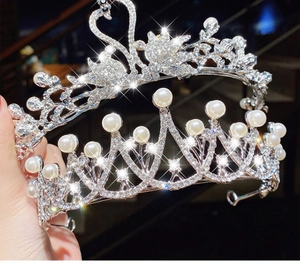 Detailed view of silver crystal tiara with white pearls and swan motif for girls
