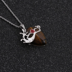 Gros plan d'un pendentif en pierre oeil de tigre avec collier chaîne torsadée argent