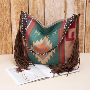 Detail of bohemian tote bag featuring ethnic patterns, leather straps and long fringes