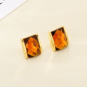 Detail view of 18K gold-plated amber glass earrings with faceted square cut stones