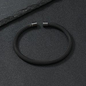 Detail of minimalist black mesh stainless steel cuff bracelet with smooth cylindrical ends